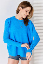 Woman wearing a blue sweater and denim shorts against a white background