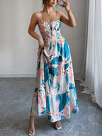 Woman wearing a floral dress with blue and pink patterns in a minimalistic room.