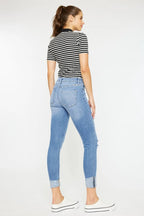 Woman wearing a striped shirt and blue jeans on a white background