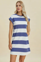 Woman wearing a blue and white striped dress on a beige background