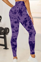 Person wearing purple tie-dye leggings in a gym setting