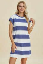 Woman wearing a blue and white striped dress on a beige background