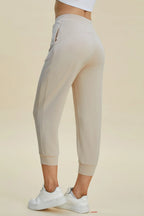 Beige jogger pants worn by a person on a beige background